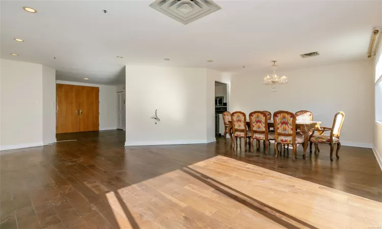 Dining space with dark wood-type flooring and a chandelier