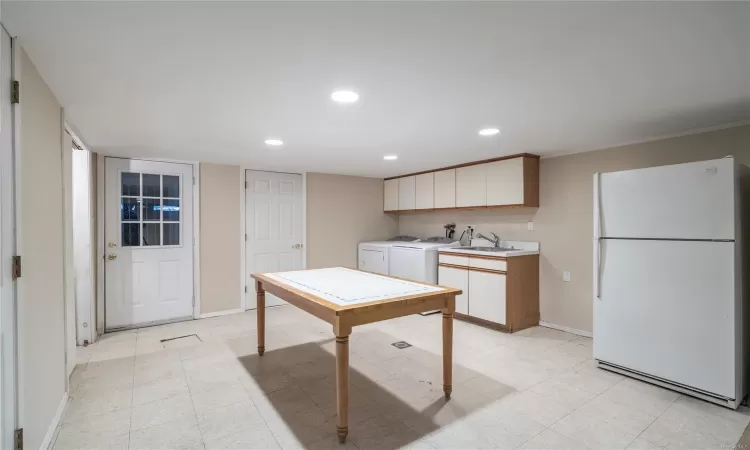 Kitchen with crown molding, sink, white cabinets, washing machine and dryer, and white fridge