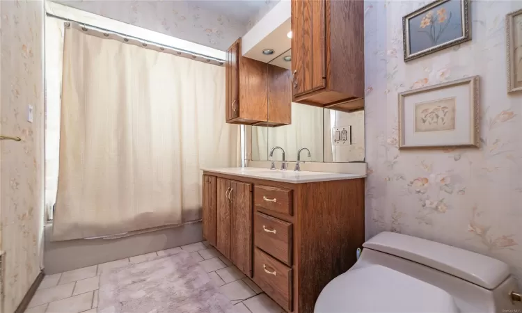 Full bathroom featuring tile patterned floors, vanity, shower / bath combo, and toilet