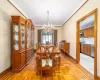 Dining area featuring light parquet flooring, crown molding, and an inviting chandelier