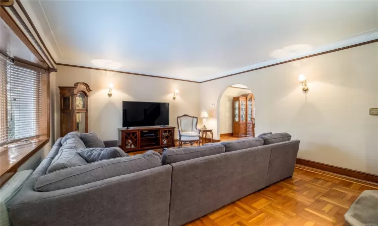 Living room with parquet flooring and ornamental molding