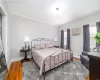 Bedroom with wood-type flooring, a baseboard heating unit, and ornamental molding