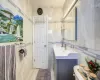 Bathroom featuring vanity, toilet, and tile walls