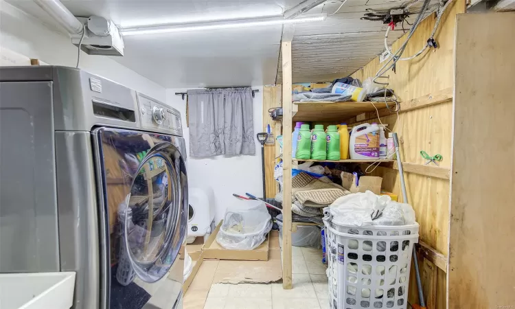 Laundry room with washer / dryer and light tile patterned flooring