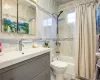 Full bathroom featuring vanity, shower / tub combo, tile walls, and toilet