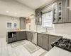 Kitchen featuring dishwasher, sink, gray cabinets, a wall mounted AC, and range