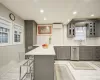 Kitchen featuring sink, a kitchen breakfast bar, stainless steel dishwasher, a wall mounted AC, and gray cabinets