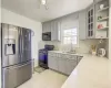 Kitchen featuring gray cabinetry, decorative backsplash, sink, and stainless steel appliances