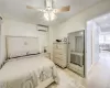 Bedroom with a closet, ceiling fan, light hardwood / wood-style flooring, and a wall mounted air conditioner