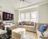 Living room featuring a wall mounted air conditioner, ceiling fan, light hardwood / wood-style floors, and vaulted ceiling