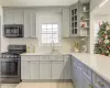 Kitchen featuring backsplash, stainless steel appliances, gray cabinetry, and sink