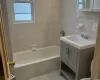 Full bathroom featuring vanity, tile walls, tile patterned flooring, radiator heating unit, and tiled shower / bath