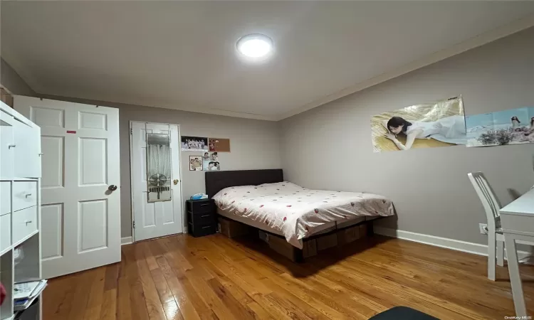 Bedroom with light hardwood / wood-style flooring and crown molding