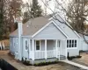 View of front facade with a garage, an outdoor structure, and covered porch