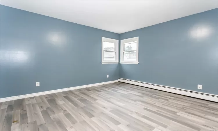 Unfurnished room with light hardwood / wood-style flooring and a baseboard radiator