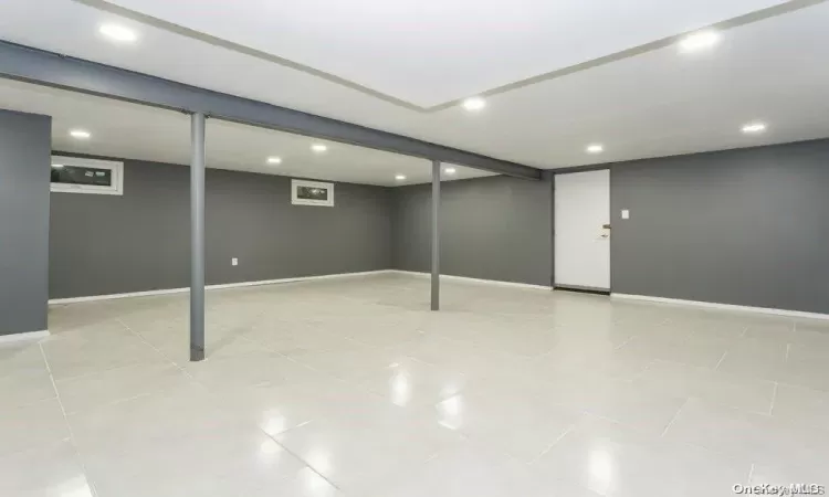 Basement with light tile patterned floors and a paneled ceiling