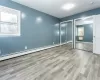 Unfurnished bedroom with multiple windows, multiple closets, and light hardwood / wood-style floors