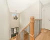 Stairs with hardwood / wood-style flooring and a notable chandelier