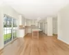 Kitchen featuring white cabinetry, a center island, decorative light fixtures, custom range hood, and light wood-type flooring