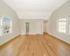 Empty room with light hardwood / wood-style flooring and lofted ceiling