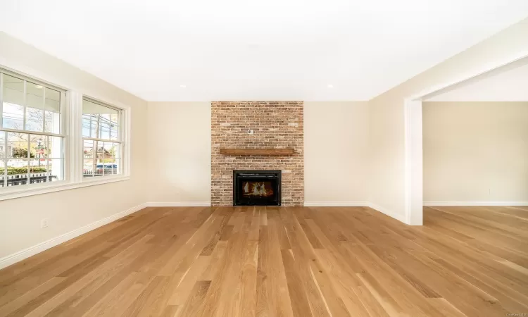 Unfurnished living room with a fireplace and light hardwood / wood-style floors