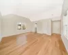 Unfurnished living room featuring light hardwood / wood-style floors and vaulted ceiling