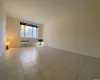 Hallway with light tile patterned floors and radiator