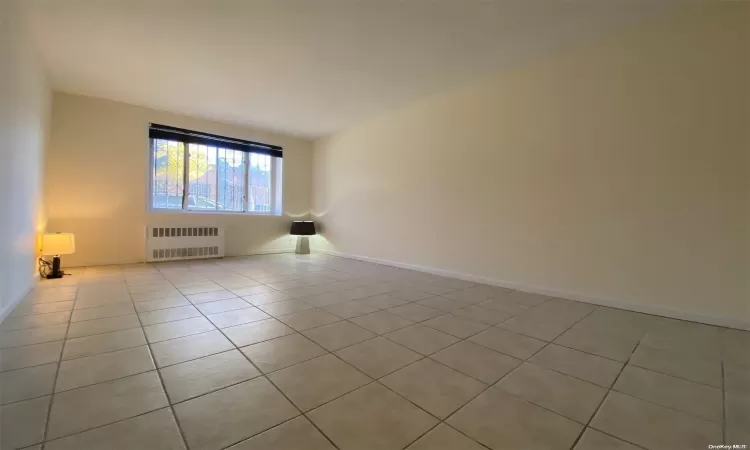 Hallway with light tile patterned floors and radiator