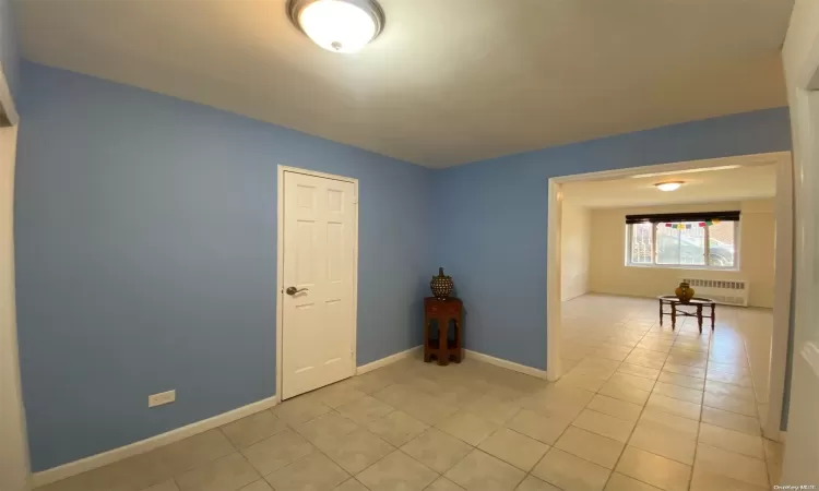 Hallway with radiator, light tile patterned floors, and sink