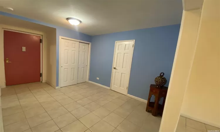 Kitchen featuring white cabinets, extractor fan, stainless steel appliances, sink, and light tile patterned flooring