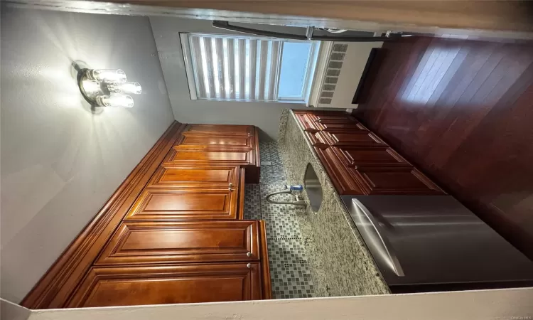 Kitchen with decorative backsplash, dark hardwood / wood-style flooring, radiator, dishwashing machine, and sink