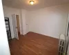 Unfurnished room with dark hardwood / wood-style flooring and radiator heating unit