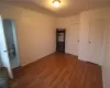 Unfurnished room featuring radiator heating unit and dark wood-type flooring