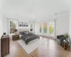 Bedroom featuring access to outside, crown molding, and light wood-type flooring