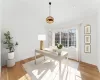 Home office featuring lofted ceiling, light hardwood / wood-style flooring, and crown molding