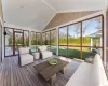 Sunroom featuring vaulted ceiling with beams and plenty of natural light