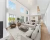 Living room featuring high vaulted ceiling, a chandelier, and light wood-type flooring