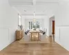 Dining room featuring beamed ceiling, light hardwood / wood-style flooring, ornamental molding, and coffered ceiling