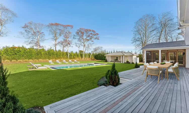 Deck featuring a lawn and a sunroom