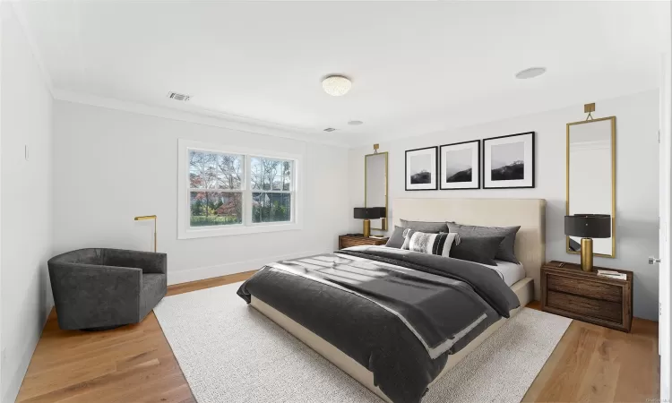 Bedroom with light hardwood / wood-style floors and crown molding