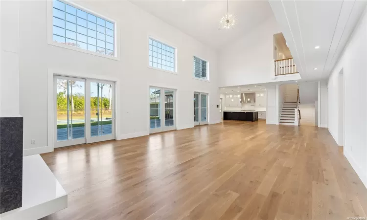 Living room featuring a chandelier, light hardwood / wood-style flooring, and high vaulted ceiling