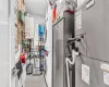 Utility room featuring stacked washer / dryer and water heater