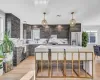 Kitchen featuring light hardwood / wood-style floors, a center island, a healthy amount of sunlight, and appliances with stainless steel finishes