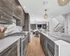 Kitchen featuring ceiling fan, pendant lighting, high quality appliances, dark brown cabinets, and light wood-type flooring