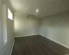 Empty room featuring high vaulted ceiling, a healthy amount of sunlight, and dark hardwood / wood-style floors