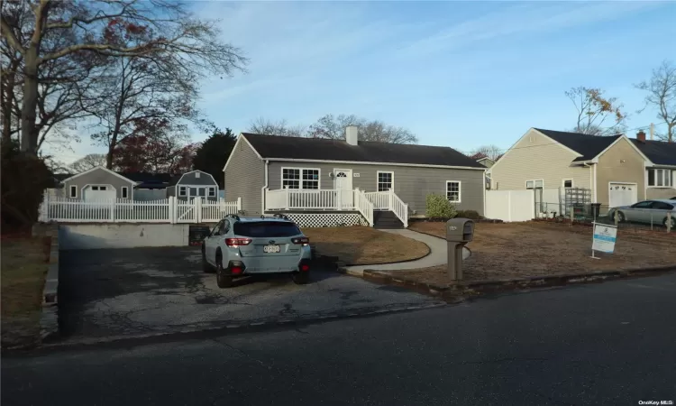 Single story home featuring a deck and a front yard