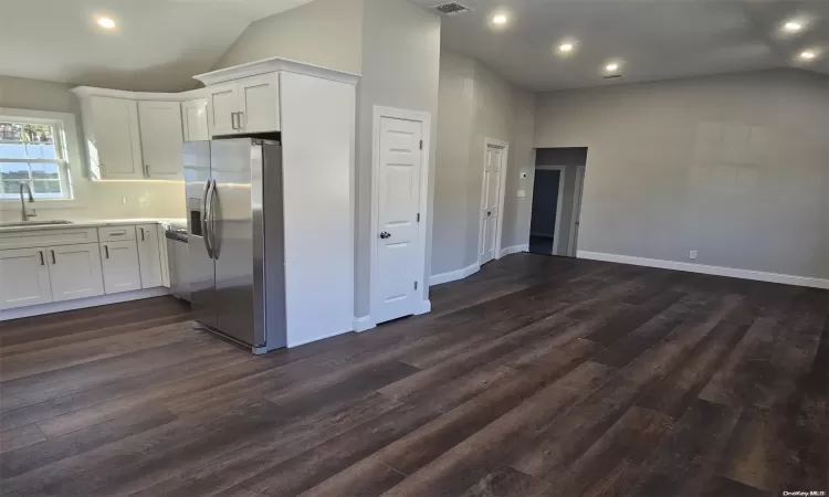 Entrance foyer with dark hardwood / wood-style flooring and lofted ceiling