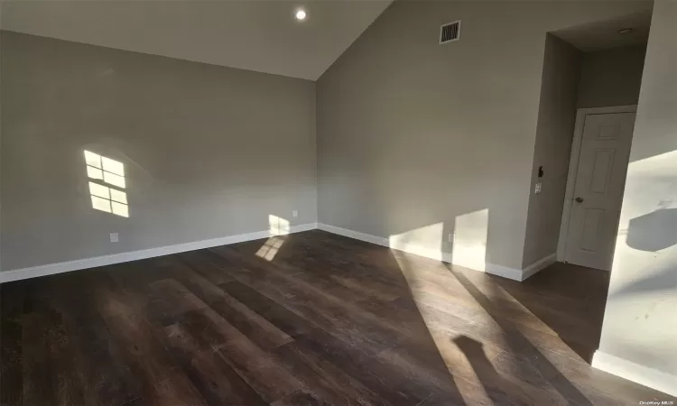 Unfurnished room featuring a wealth of natural light, ceiling fan, and dark hardwood / wood-style floors