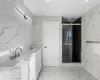 Bathroom featuring vanity, tile walls, and walk in shower