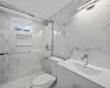 Bathroom with vanity, toilet, and a shower with door